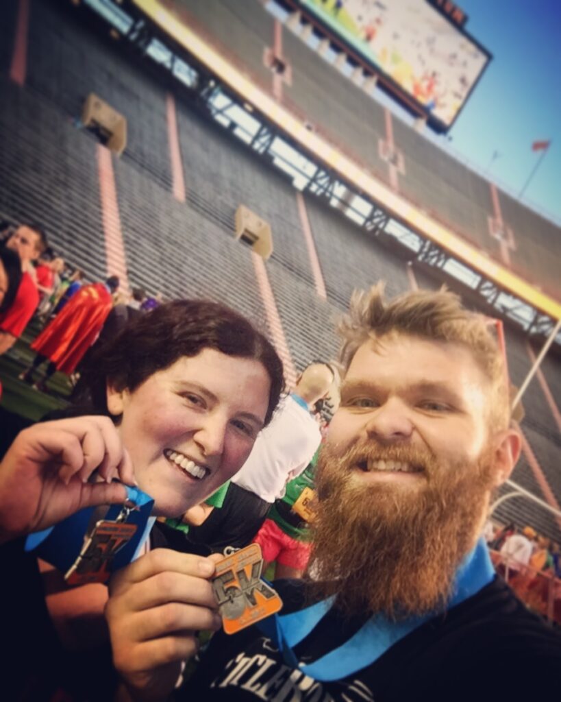 Two runners holding up medals