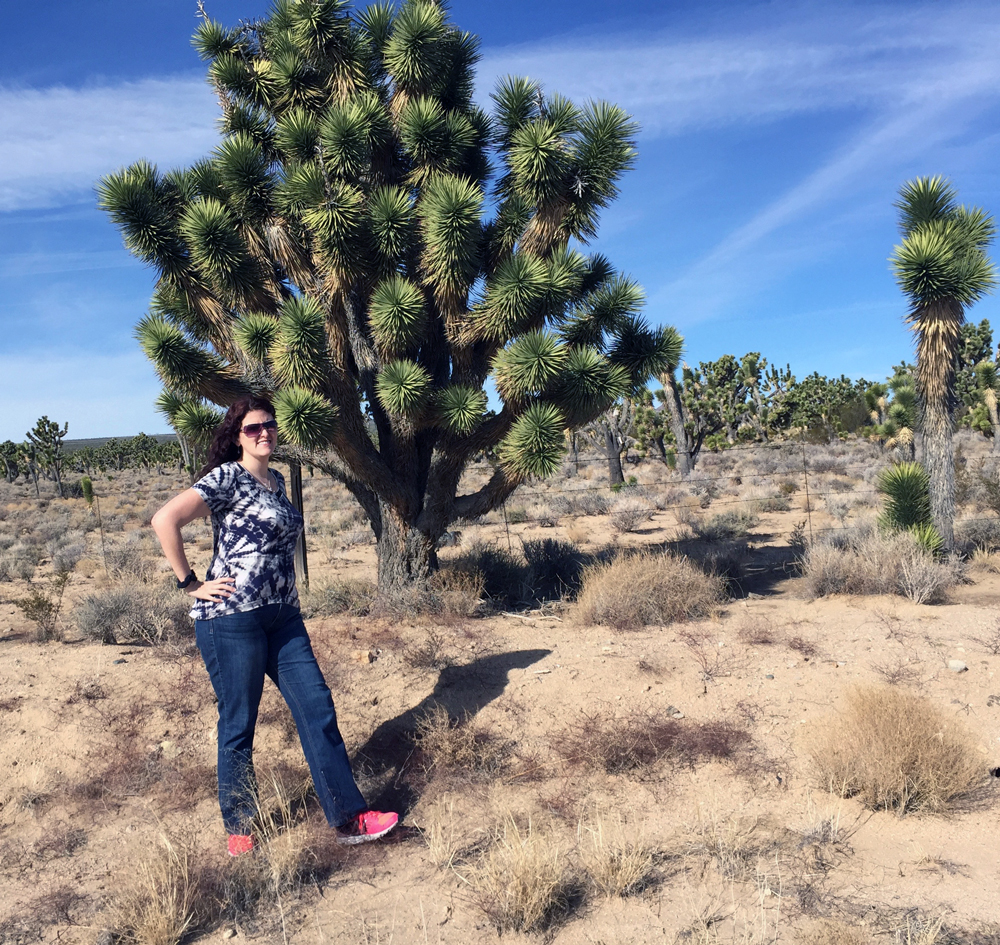 girl standing in front of a joshua tree